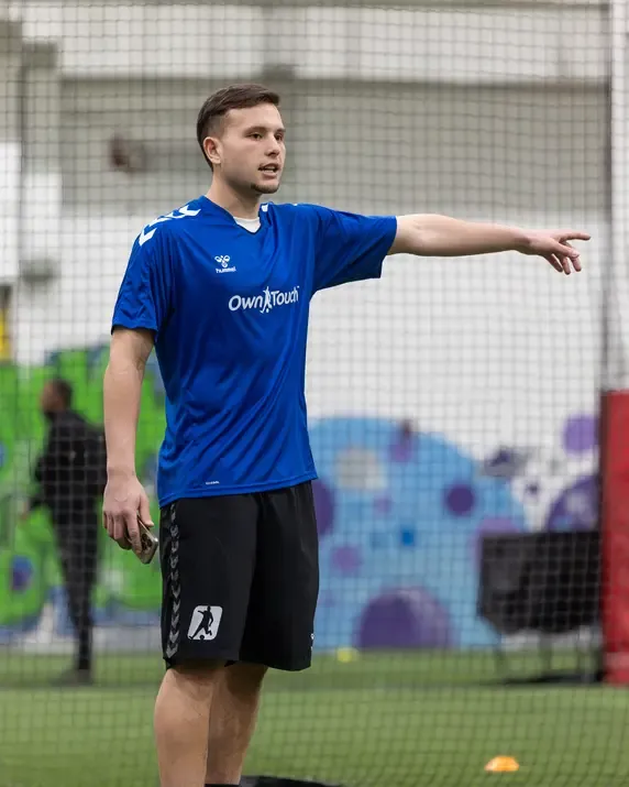 An Own Touch coach directing play from the touchline on the indoor pitch