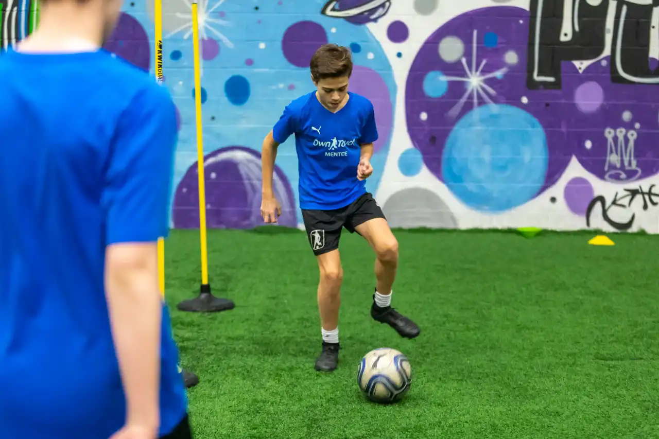 An Own Touch Mentee controlling the ball in front of the studio’s graffiti mural