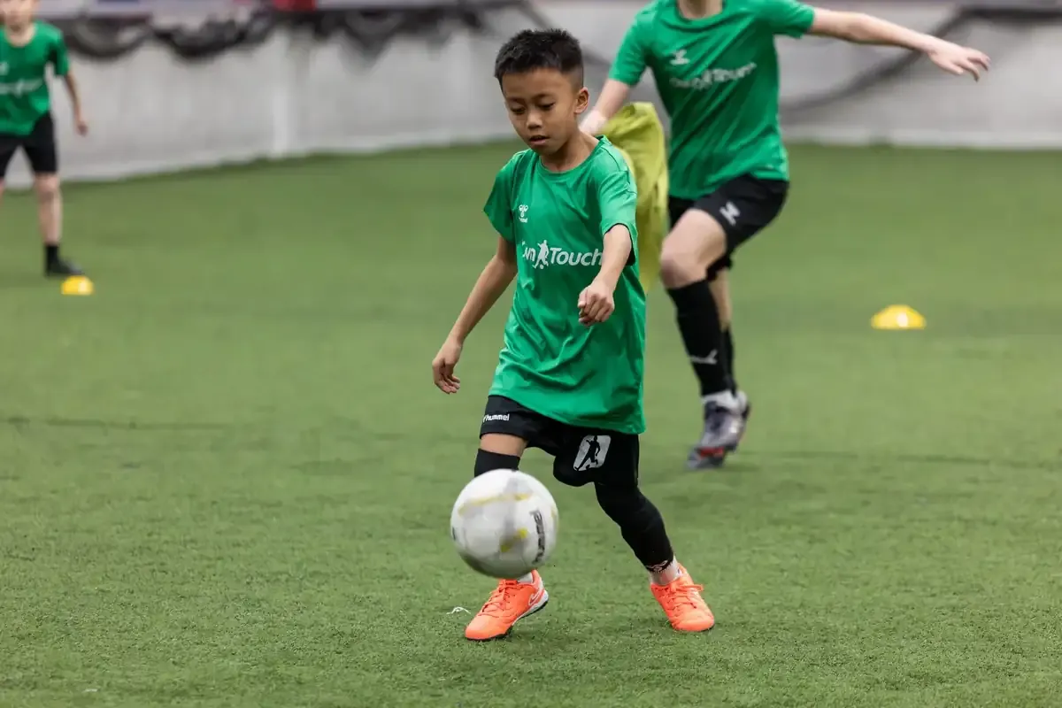 Players moving through a footwork drill on the indoor turf at Own Touch Soccer