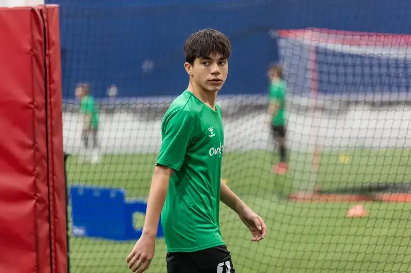A player moving off the ball beside the goal during training