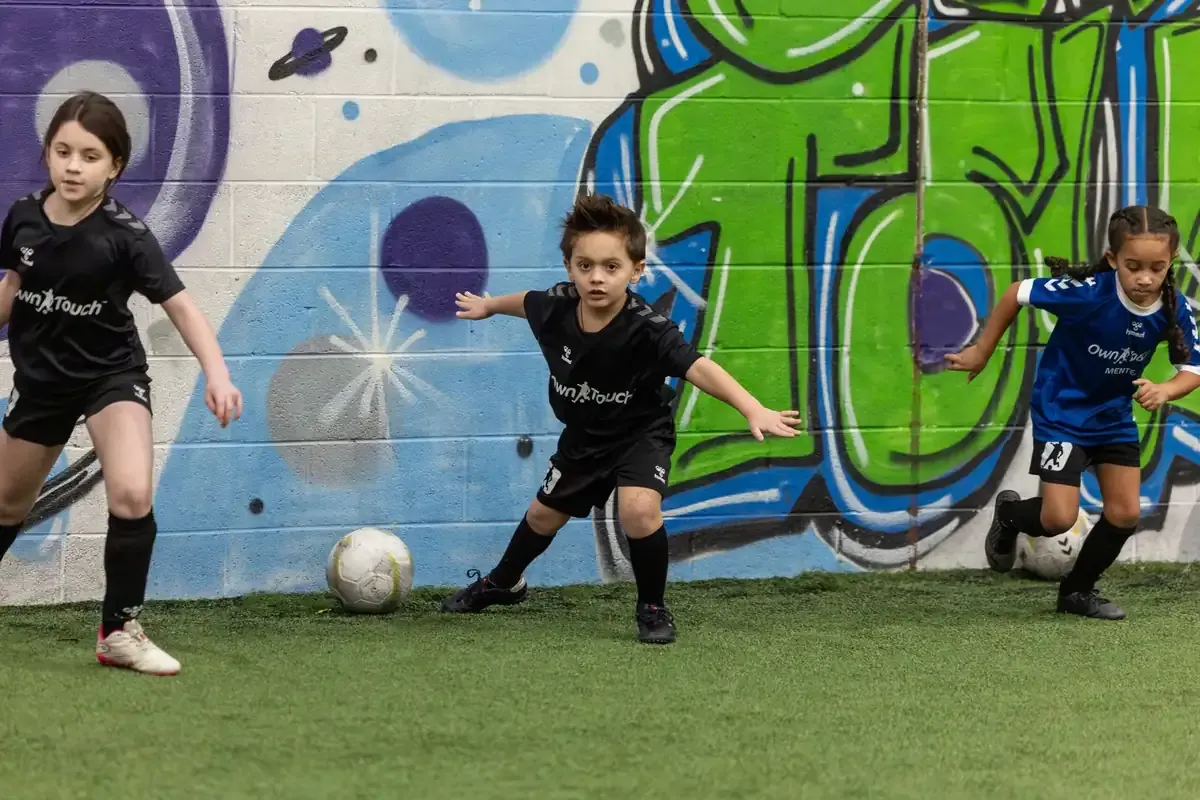 Players training together in front of the Own Touch mural