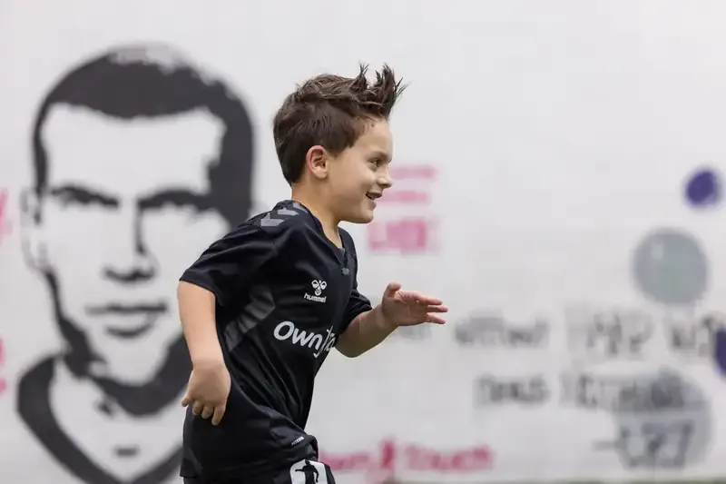 A young player sprinting past the studio's painted wall during a session