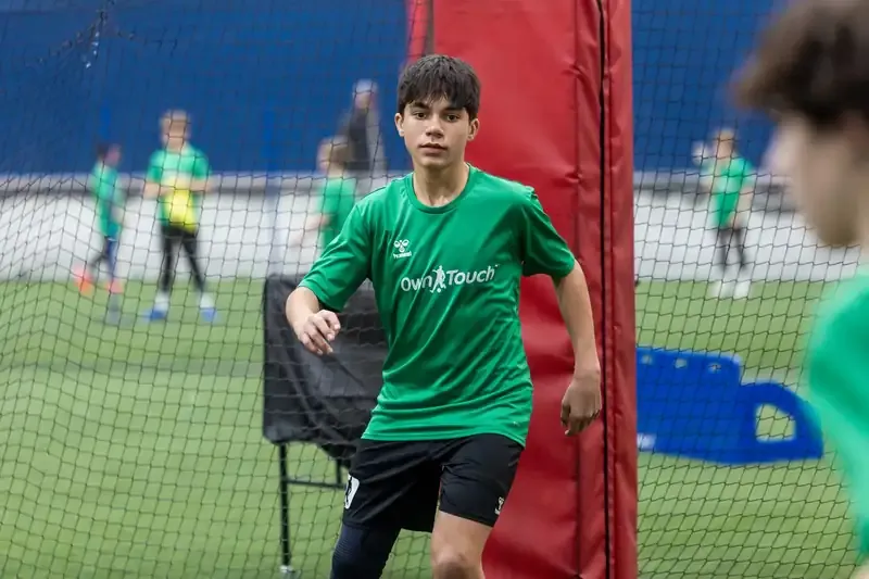A player weaving between goals and netting during an indoor session