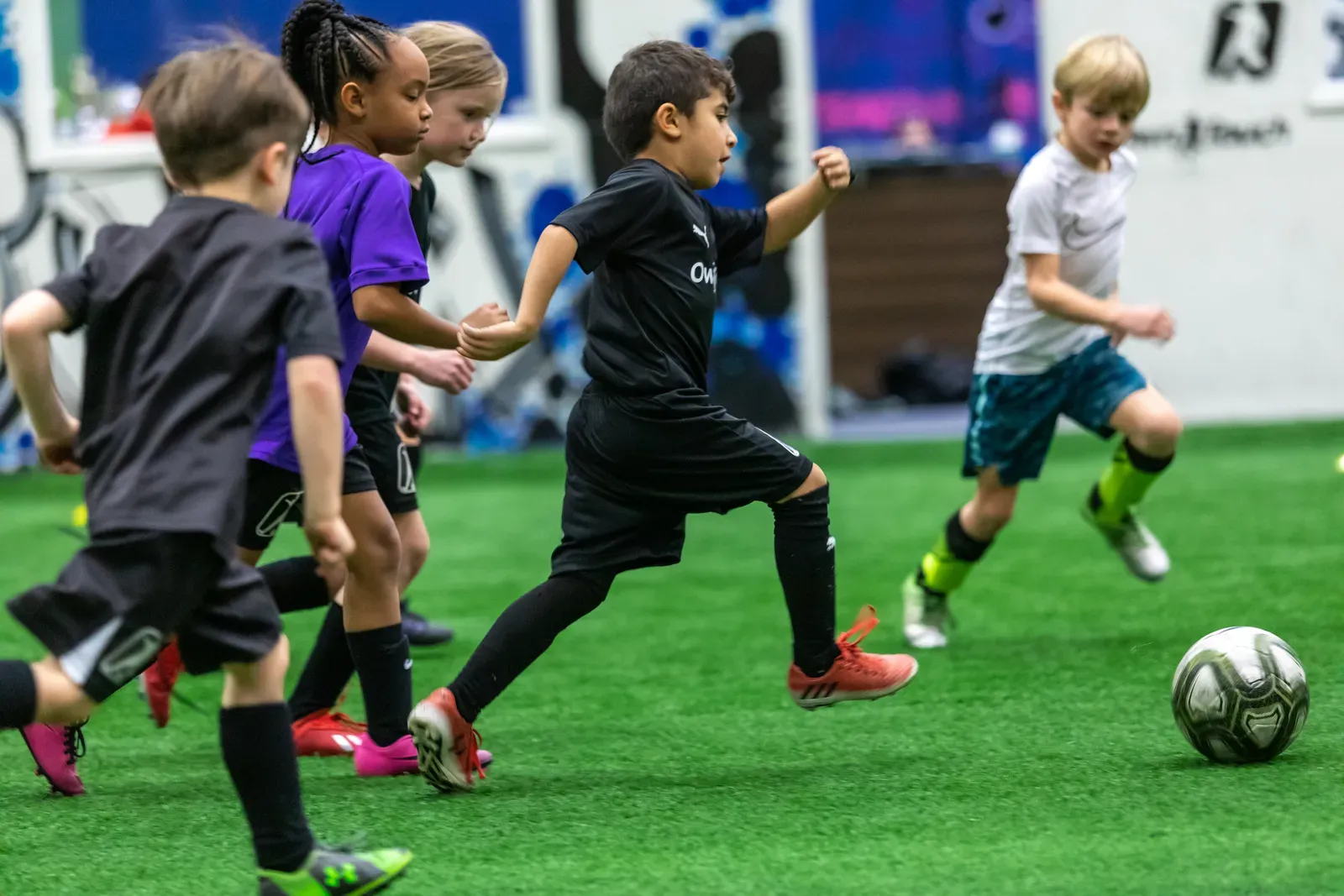 Mini Mentees chasing the ball in a small-sided game