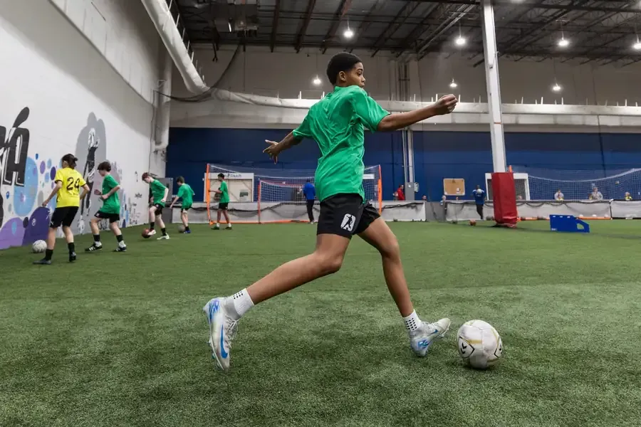 Prospect driving at a defender during a match-realistic session