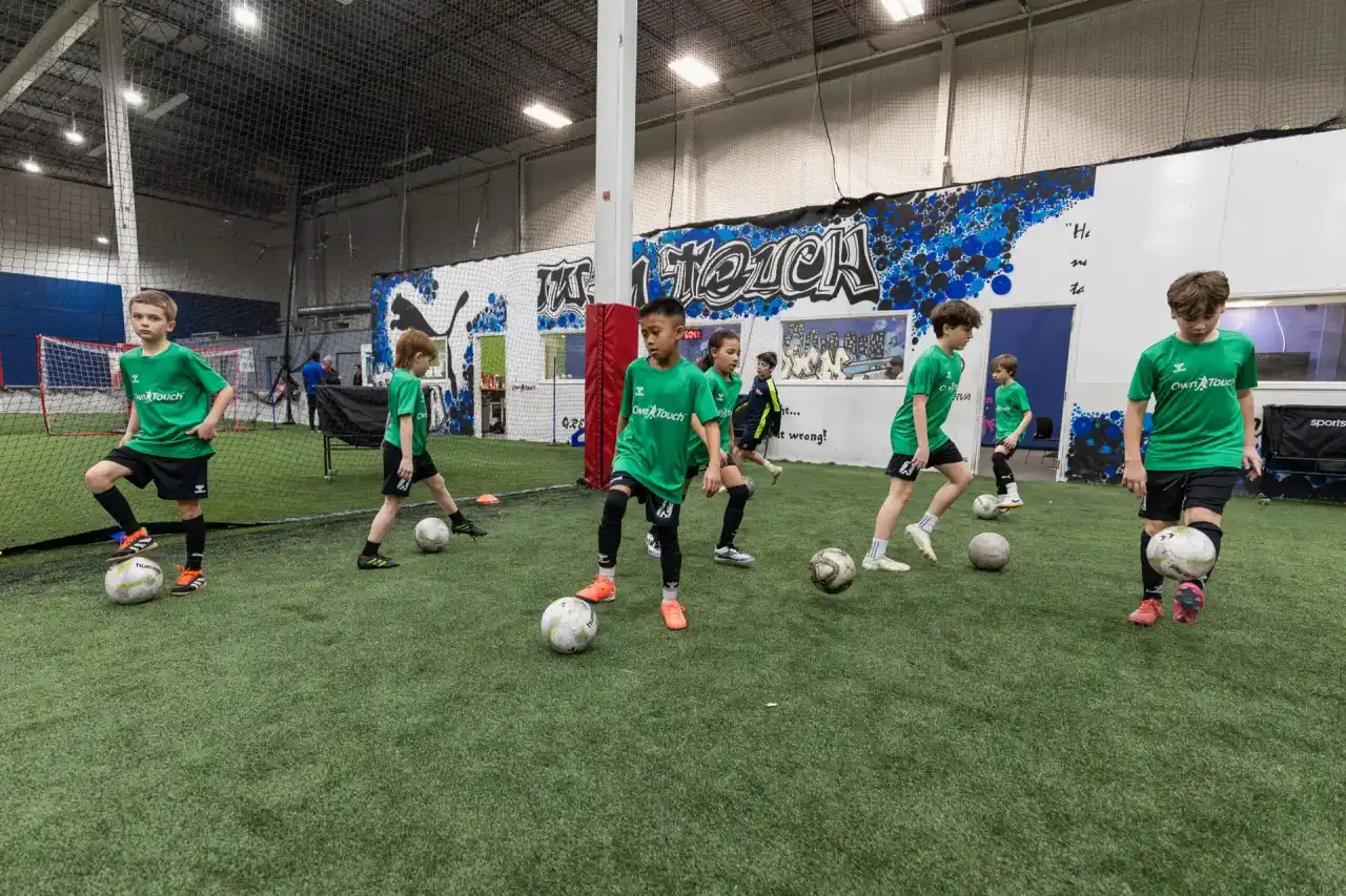 A full training session underway on the indoor turf at Own Touch Soccer