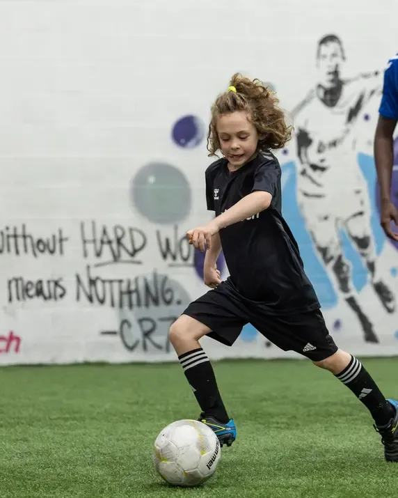 A player working through a ball-mastery drill with a coach
