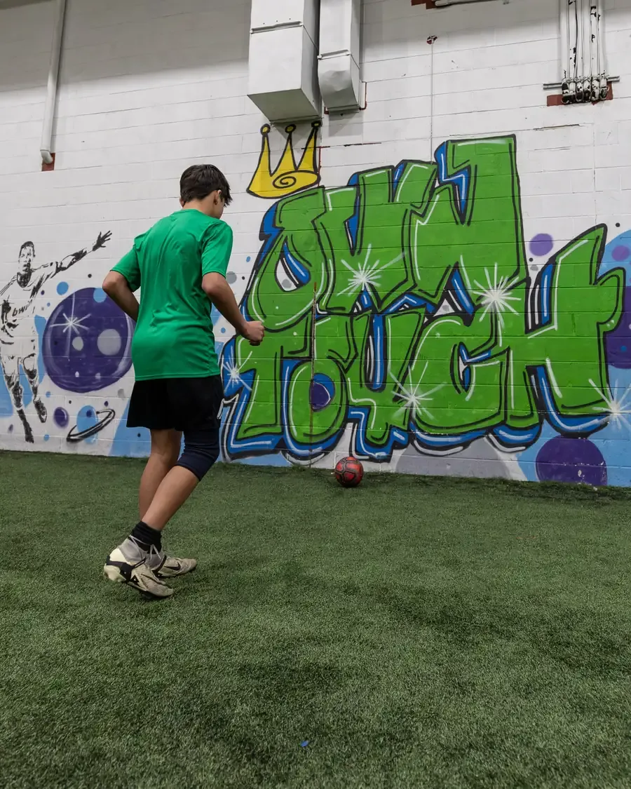 Player working on the ball in front of the Own Touch mural